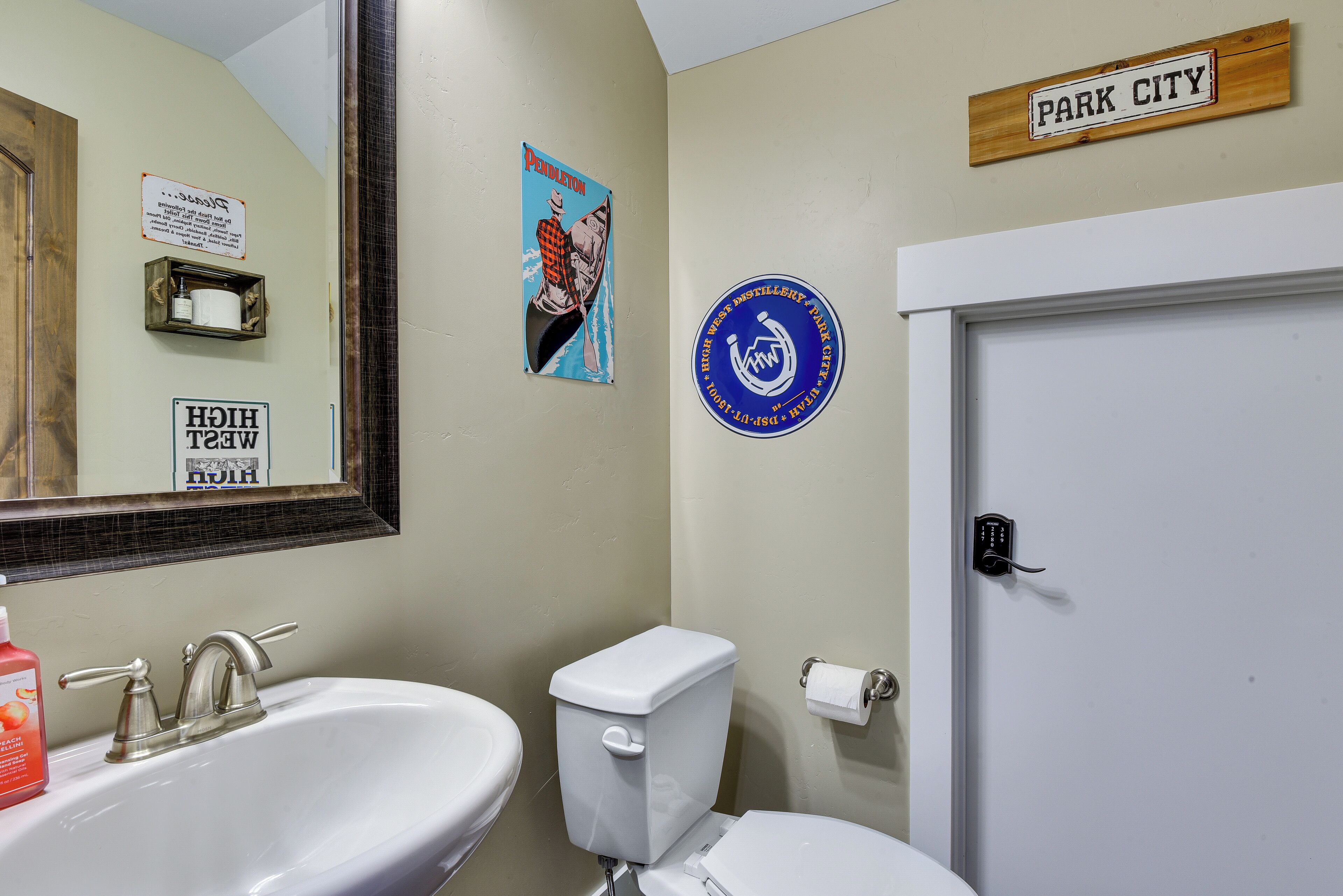 A bathroom with a sink, toilet, and a door labeled "PARK CITY".