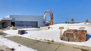 Un edificio moderno con una gran estructura metálica en arco y una placa que dice 'The Miner's Legend'.