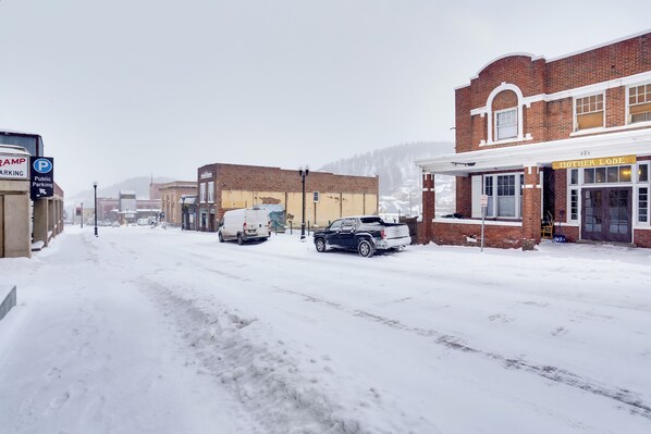 A snow-covered street with buildings, including a visible storefront named "Mother Lode."
