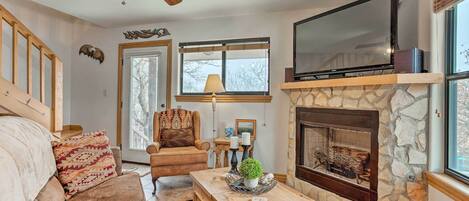 A cozy living room with a fireplace, a large TV, and a comfortable sofa.