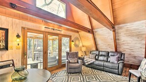 A cozy cabin interior with a leather sofa, a recliner, and a dining table. - Lake Hamilton Cabin: Boating Getaway! (Hot Springs)
