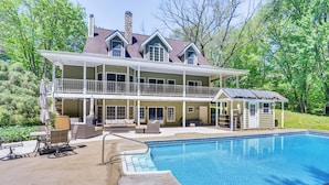 A two-story house with a large swimming pool, outdoor furniture, and a covered patio area. - Huge Family Home w/ Pool - 13 Mi to Lake Michigan! (La Porte)