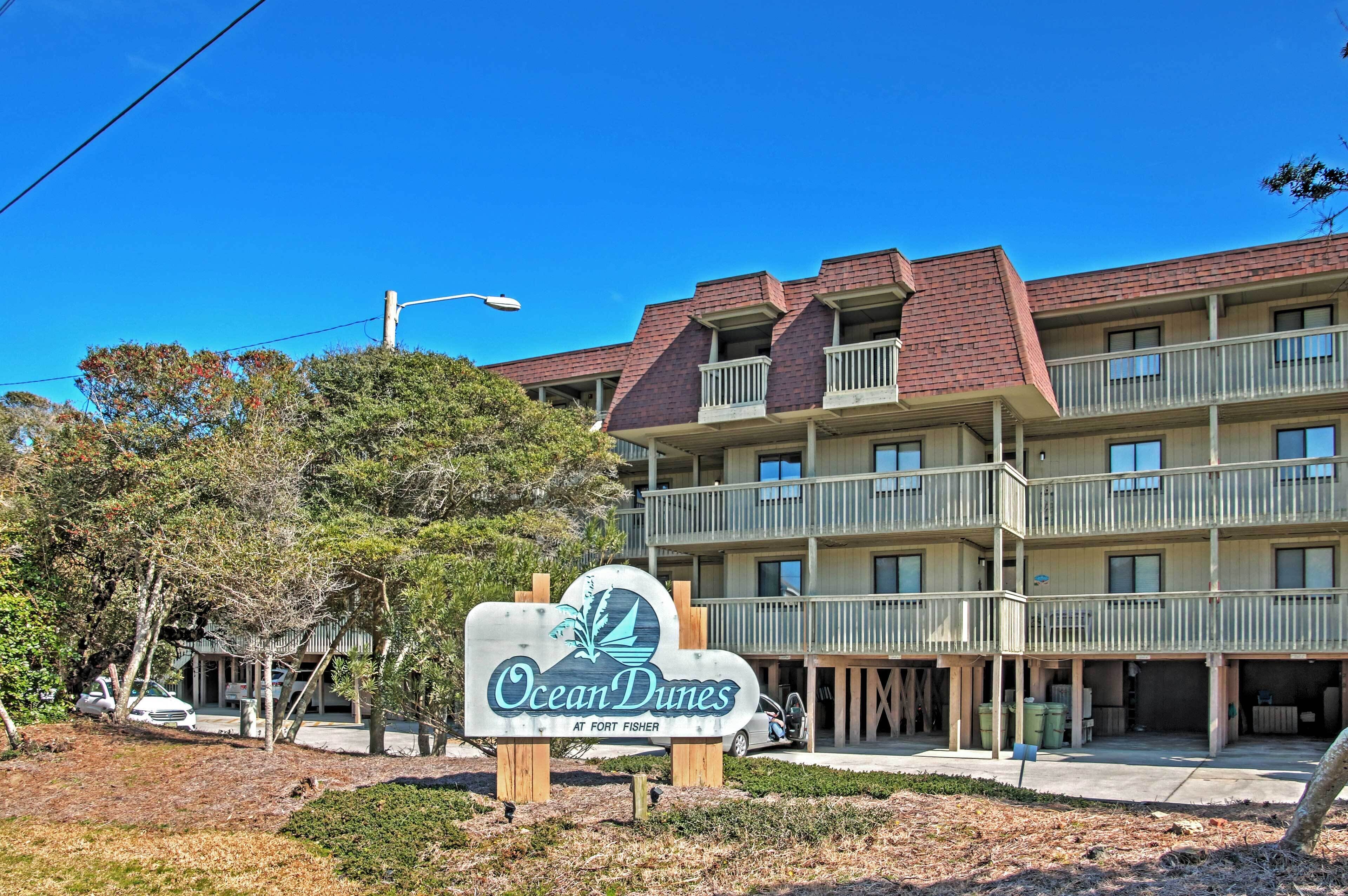 A multi-story hotel with a sign reading "Ocean Dunes at Fort Fisher."