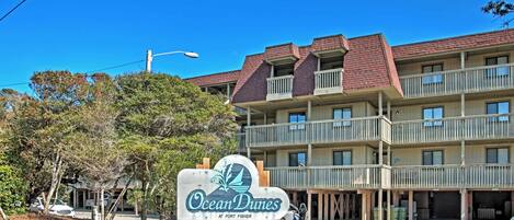 A multi-story hotel with a sign reading "Ocean Dunes at Fort Fisher."