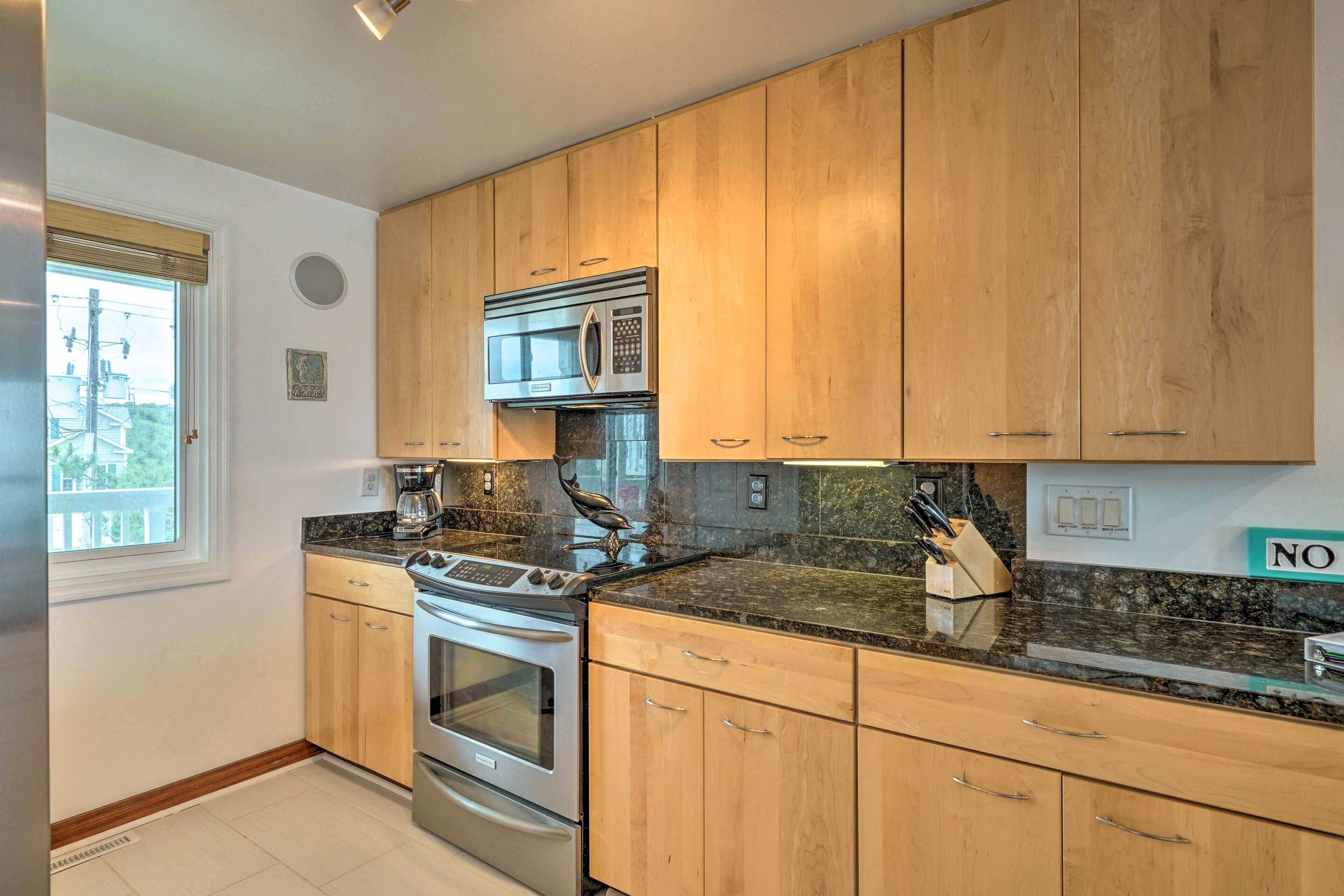 A modern kitchen with wooden cabinets, stainless steel appliances, and a granite countertop.