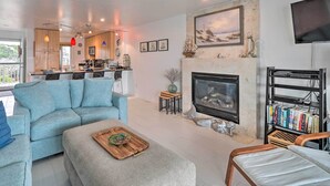 Una sala de estar moderna con chimenea, un sofá, una mesa de centro y una estantería.