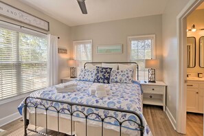 A bedroom with a bed, two bedside tables, a nightstand, a window with blinds, and a wall-mounted picture. - Steps to Sand: Hilton Head Retreat w/ Pool Access! (Hilton Head Island)