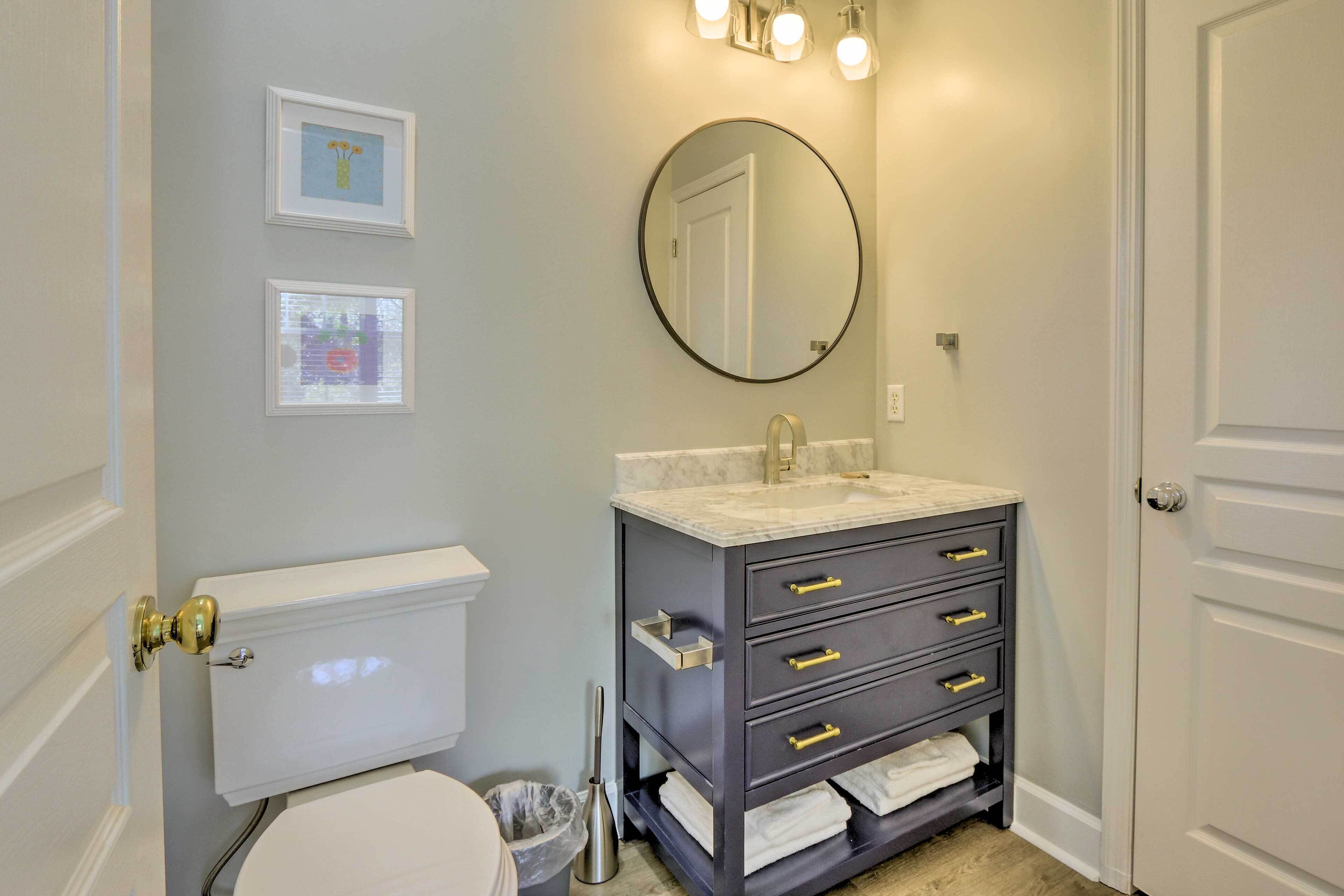 A bathroom with a toilet, sink, and vanity.