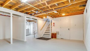 A spacious room with a wooden ceiling, white walls, and a white floor.