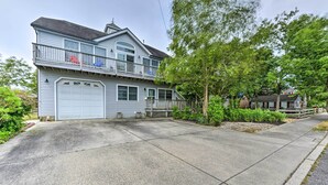 Een twee verdiepingen tellend huis met garage, een balkon met hekwerk en een oprit die naar de garage leidt.