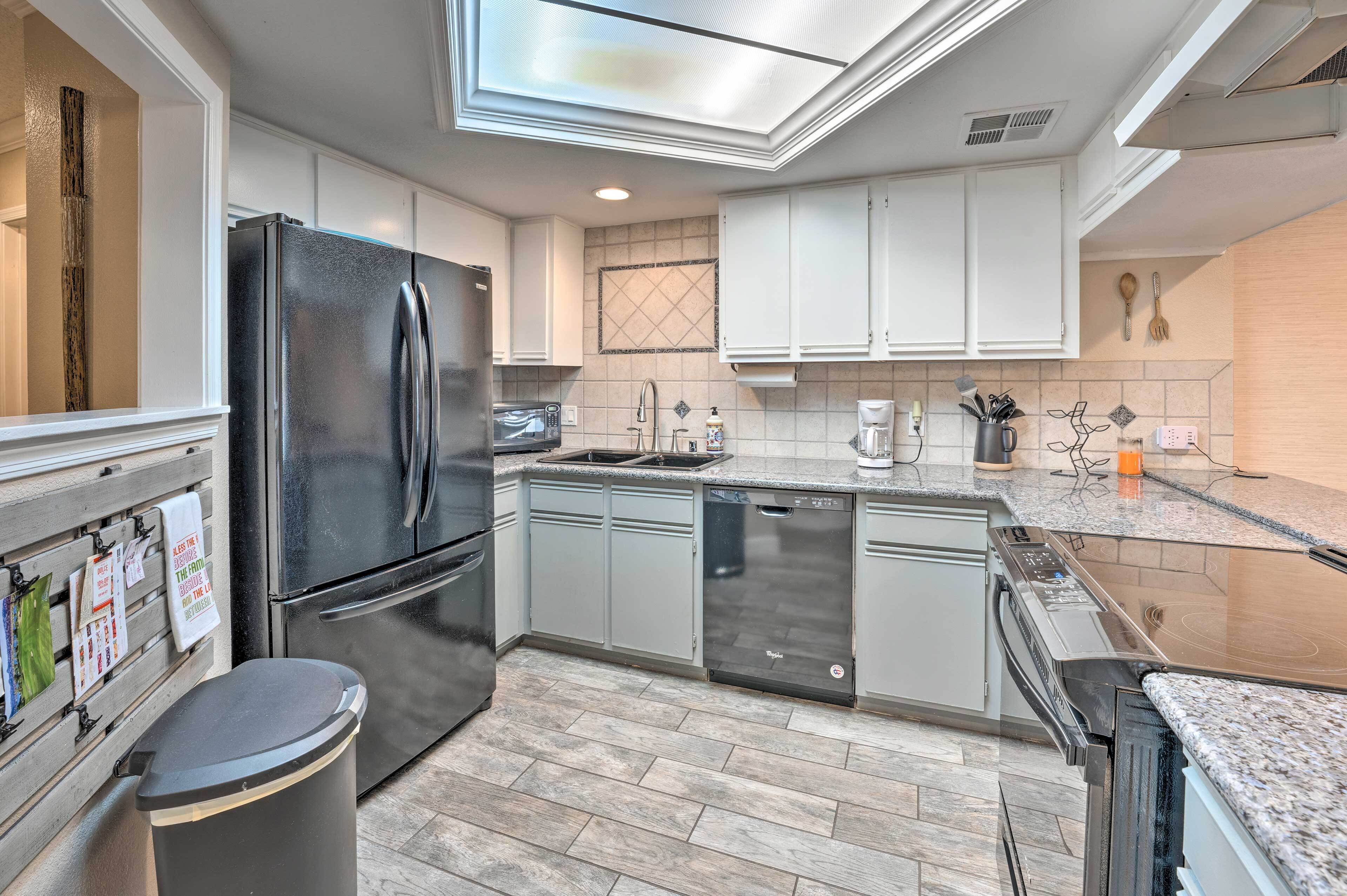 A modern kitchen with stainless steel appliances, a dishwasher, and a microwave.