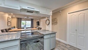 A modern kitchen with granite countertops, a built-in stove, and a dining area with a bench. - Walk to Beach: Lake Havasu Condo w/ Pool Access (Lake Havasu City)
