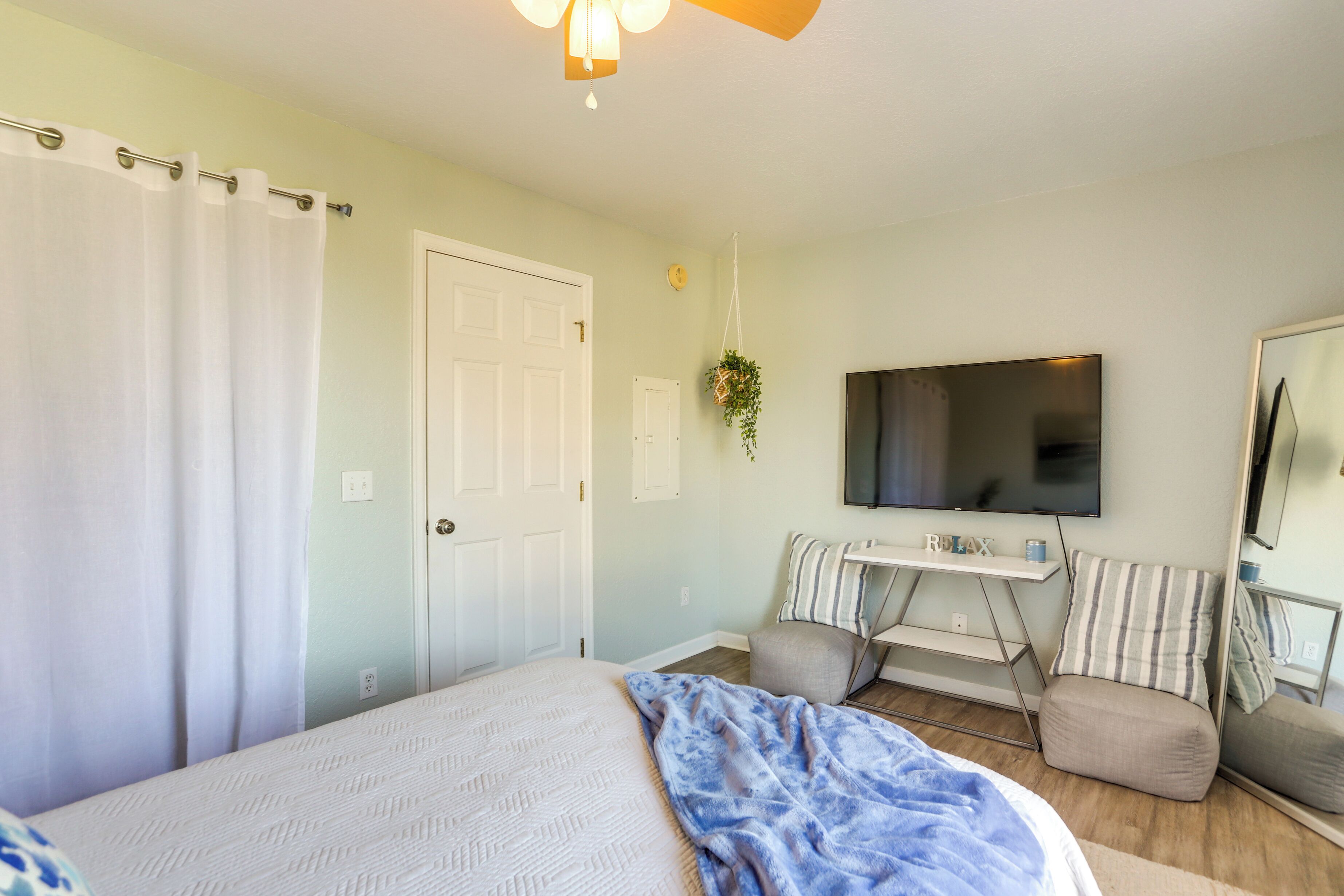 Une chambre à coucher avec un lit, une télévision, un bureau et une chaise.