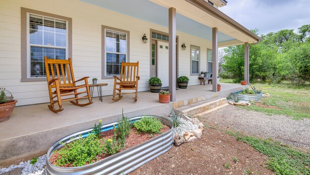 A house with a covered porch, two rocking chairs, and potted plants. - 'fox Ridge Farmhouse' - Hill Country Getaway! (San Marcos)