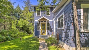 A two-story house with a front porch, a visible front door, and a pathway leading to the entrance. - Crystal Lake Cottage: Kayaks & Fire Pit! (Plymouth)