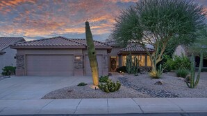 A residential house with a garage, a large cactus, and a tree in the front yard. - Sun City Grand Golf Course Gem w/ Pool, Spa & Cart (Surprise)