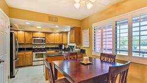 A kitchen with wooden cabinets, a microwave, stove, and a dining table with chairs. - Condo w/ Pool Access, 8 Mi to Phoenix Mtn Preserve (Phoenix)