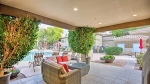 An outdoor patio area with wicker furniture, a pool, and potted plants. - Condo w/ Pool Access, 5 Mi to Tempe Diablo Stadium (Tempe)