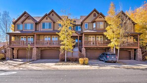 A two-story townhouse with a covered front porch, a garage, and a driveway.