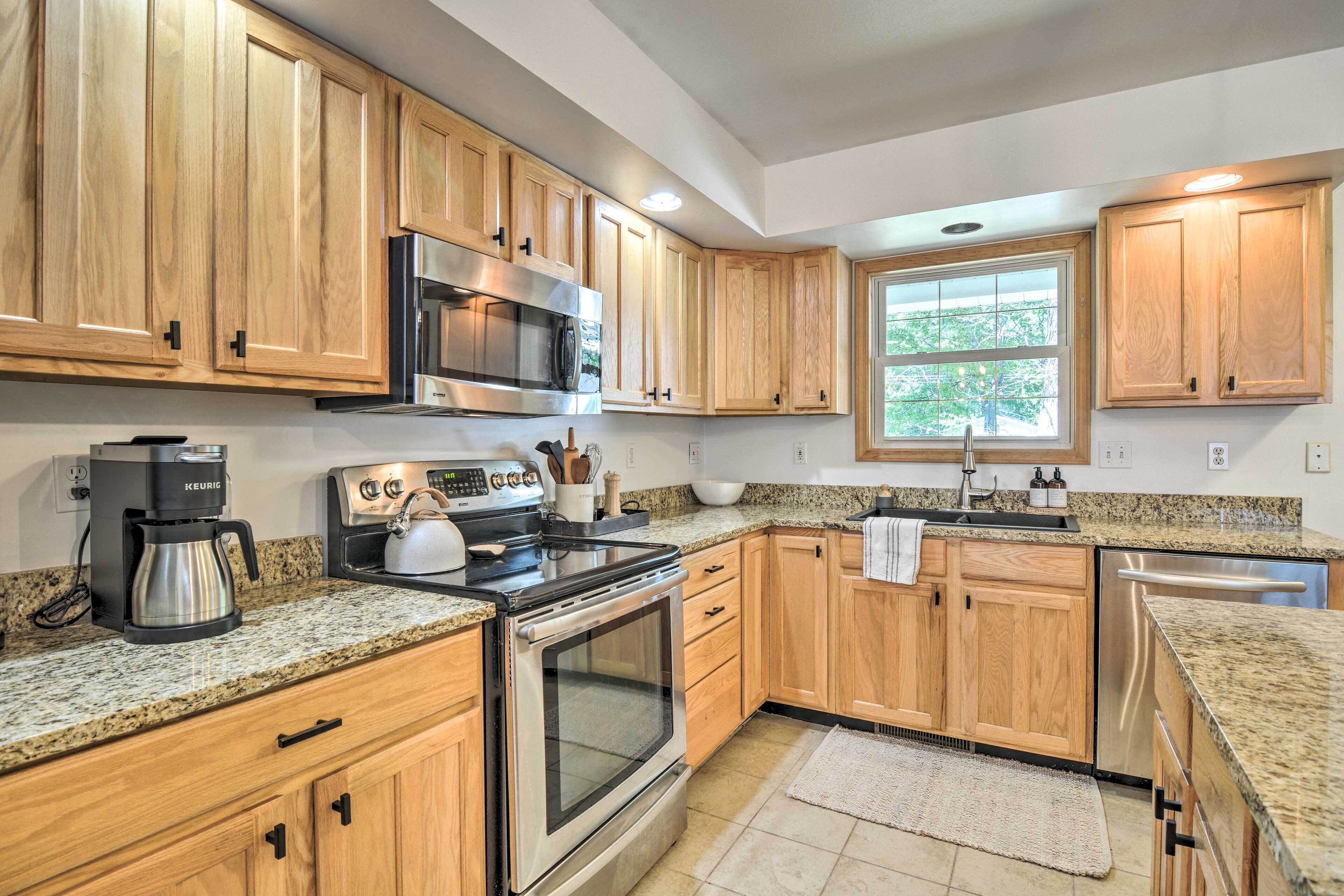 A kitchen with wooden cabinets, a stainless steel oven, a microwave, a coffee maker, and a dishwasher.