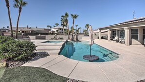 A swimming pool with a hot tub, surrounded by palm trees and a patio area with outdoor furniture. - Putting Green & Bbq: Modern Lake Havasu Oasis! (Lake Havasu City)