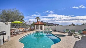 A swimming pool with a curved design, surrounded by outdoor seating and a small gazebo. - Spacious Arizona Home, 6 Mi to Old Town Scottsdale (Paradise Valley)
