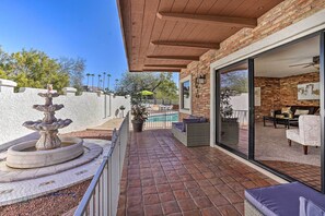 A patio with a fountain, outdoor seating, and a view of a pool and house interior. - Spacious Arizona Home, 6 Mi to Old Town Scottsdale (Paradise Valley)
