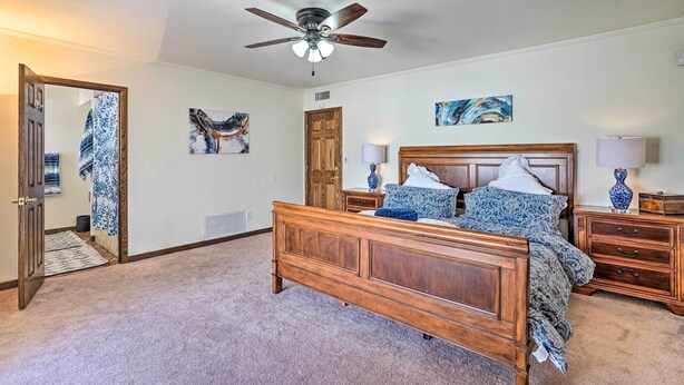 A bedroom with a wooden bed, a ceiling fan, and artwork on the walls. - Spacious Arizona Home, 6 Mi to Old Town Scottsdale (Paradise Valley)