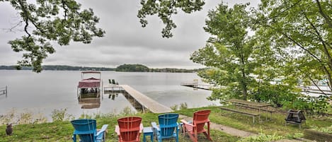 Une vue sur le lac avec un quai, des chaises et une table de pique-nique.