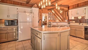 A spacious kitchen with wooden beams, a large island, and a built-in oven. - Tranquil Smoky Mountain Cabin w/ Porch & Fire Pit (Newport)