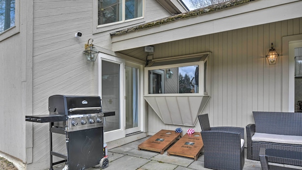 A patio area with a grill, two wooden boards labeled "House Pond," wicker furniture, and a wall-mounted lantern.