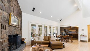 A spacious living area with a stone fireplace, a large sectional sofa, and a cowhide rug.