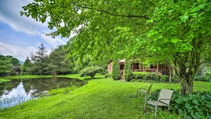 A serene garden with a pond, a wooden house, and a bench. - Serene Smoky Mountain Home w/ Grill & Patio! (Topton)