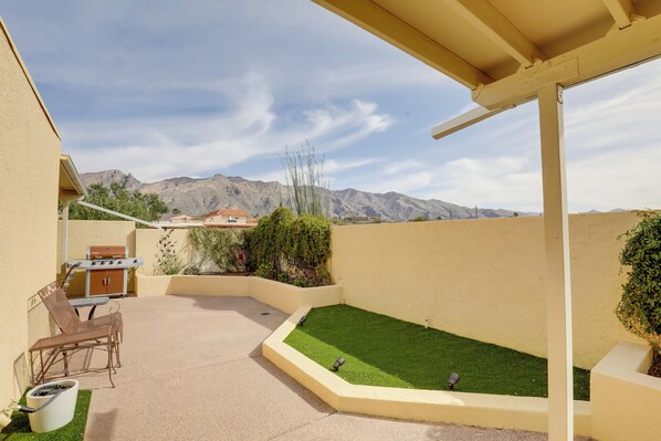 A patio area with a barbecue, seating, and a small lawn. - Tucson Townhome w/ Private Patio & Mtn Views! (Tucson)
