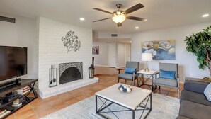 A modern living room with a fireplace, television, and seating area. - Tucson Townhome w/ Private Patio & Mtn Views! (Tucson)