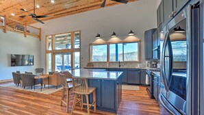 Una cocina moderna con una isla central, suelo de madera y ventanas amplias.
