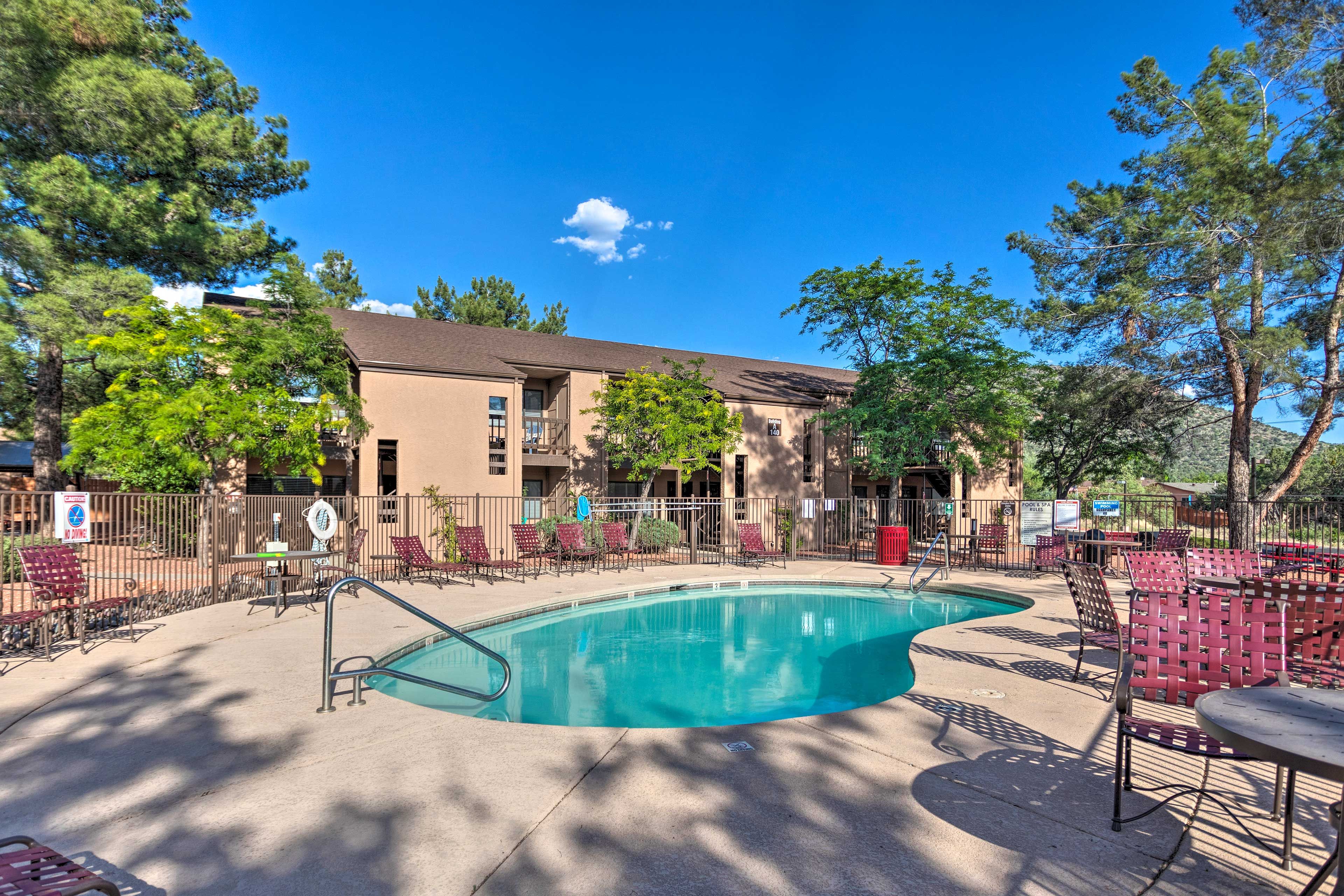 A swimming pool with lounge chairs and a building in the background.