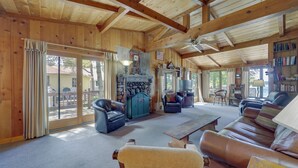 Ein geräumiges Wohnzimmer mit Kamin, Ledersofas und einer Bücherwand.