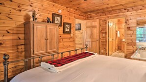 A wooden cabin room with a bed, a wardrobe, and a bathroom with a sink. - Cabin w/ Deck + Fireplace < 3 Mi to Dollywood! (Pigeon Forge)
