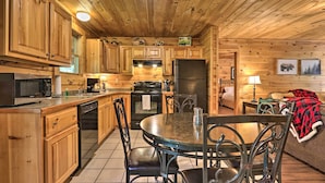 A wooden cabin interior with a kitchen, dining area, and a cozy living space. - Cabin w/ Deck + Fireplace < 3 Mi to Dollywood! (Pigeon Forge)