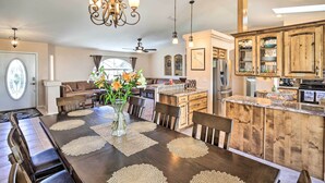 A spacious dining area with a long wooden table, surrounded by chairs, and a central vase with flowers. - Heated Pool & Game Room: Lake Havasu Retreat (Lake Havasu City)