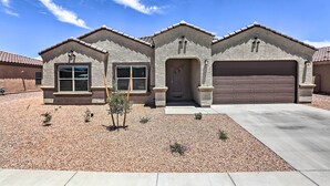 A two-story house with a garage, a front door, and a small garden area with gravel and plants. - Inviting Sahuarita Home < 5 Mi to Lake Park! (Sahuarita)