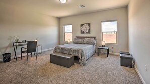 A bedroom with a bed, two bedside tables, a desk with a chair, and a window. - Inviting Sahuarita Home < 5 Mi to Lake Park! (Sahuarita)