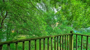 A wooden deck with a view of a lush green forest. - Cozy Duplex: Half Mi to Magic Bag & Woodward Ave! (Ferndale)