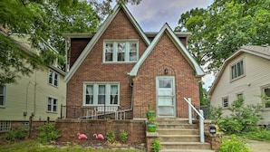 A two-story brick house with a front porch, a mailbox, and a pink flamingo decoration. - Cozy Duplex: Half Mi to Magic Bag & Woodward Ave! (Ferndale)