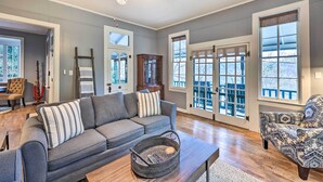 A spacious living room with a grey sofa, patterned armchair, and a wooden coffee table.