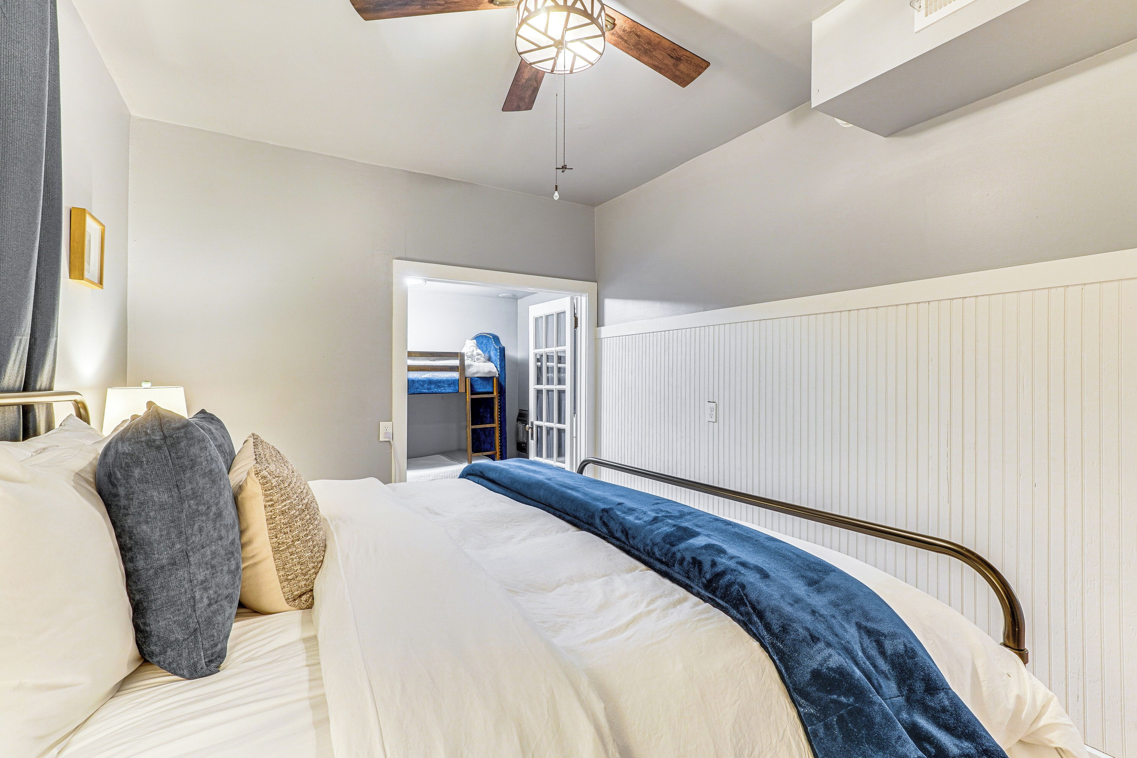 Una camera da letto con un letto, una ventola a soffitto e un termosifone.