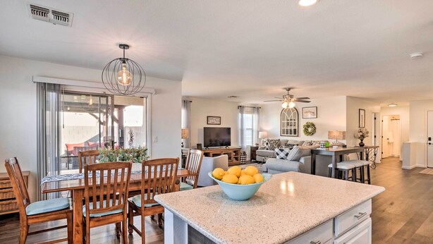 A modern kitchen with a central island, wooden dining chairs, and a bowl of lemons. - 2 Mi to State Farm Stadium: Phoenix Retreat (Phoenix)