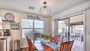 A dining area with a wooden table, chairs, and a hanging light fixture. - 2 Mi to State Farm Stadium: Phoenix Retreat (Phoenix)