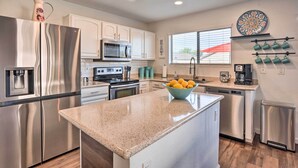 A modern kitchen with stainless steel appliances, a granite countertop, and a window with blinds. - 2 Mi to State Farm Stadium: Phoenix Retreat (Phoenix)